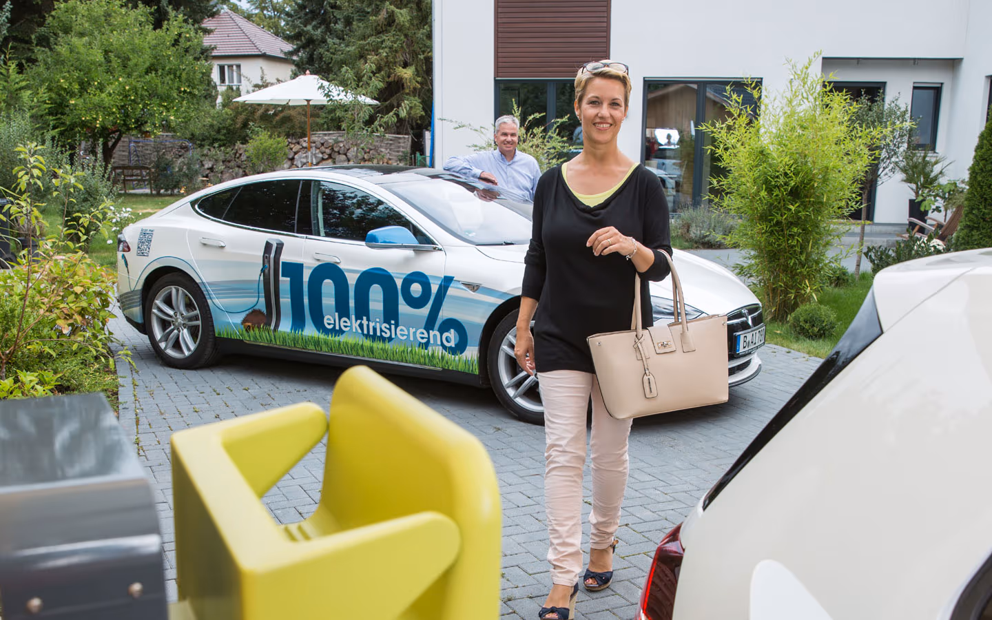 E-Mobilität - Kundin vor Elektrofahrzeugen 100% elektrisierend &middot; Hornetz